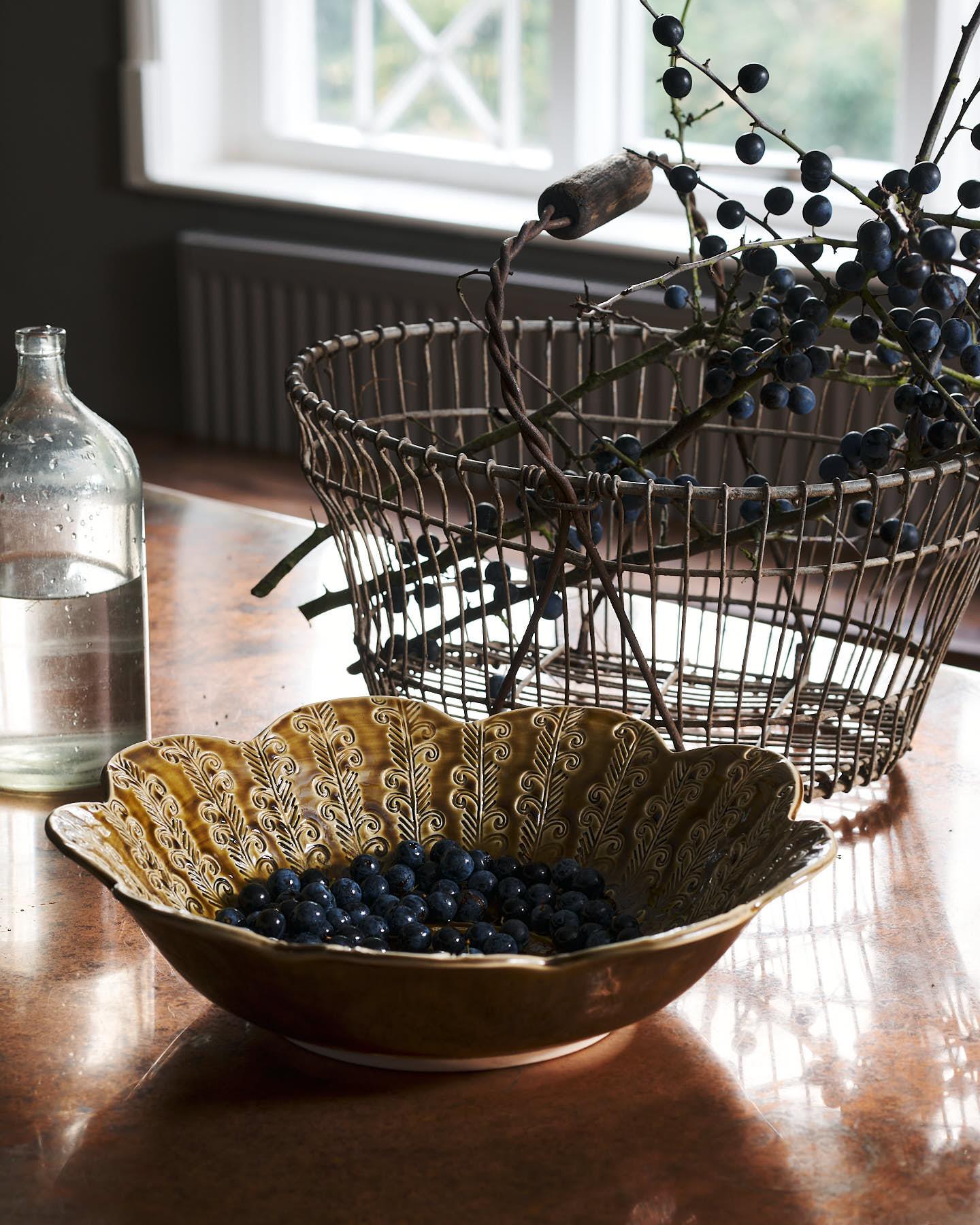 Heirloom Petal Bowl in Dark Gold Colour with blueberries on a copper worktop.