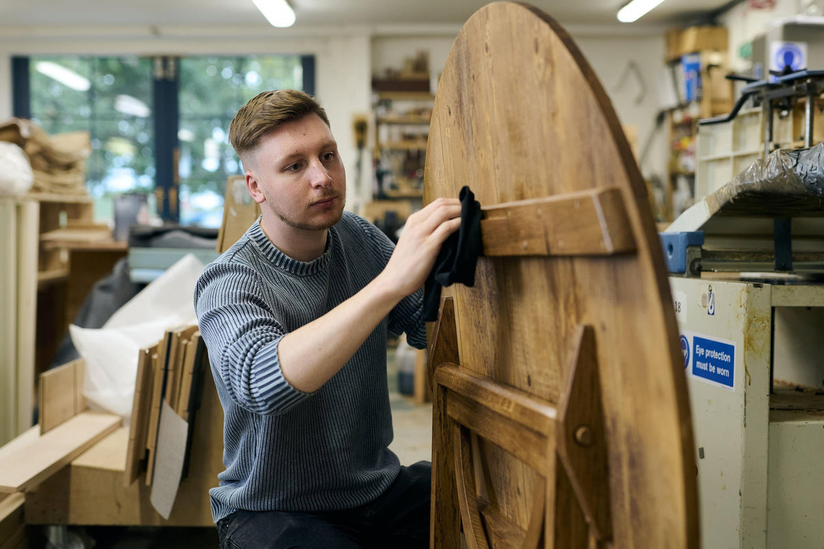 A product designer waxing the vineyard table.