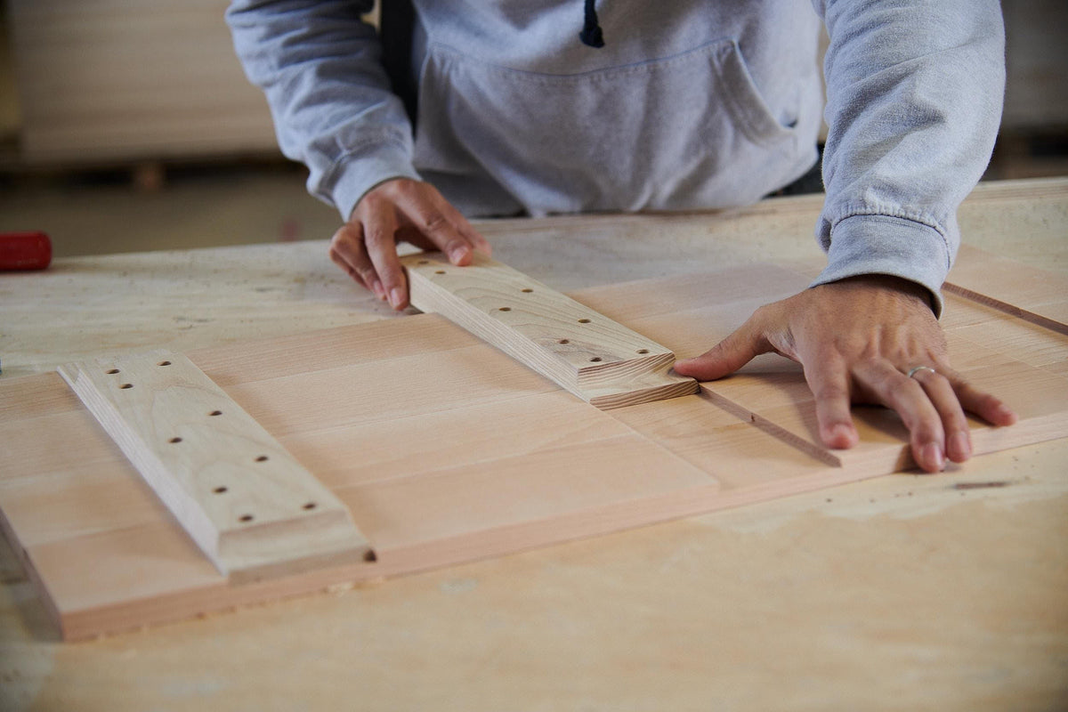 A cabinet maker effortlessly adding pieces of wood together.