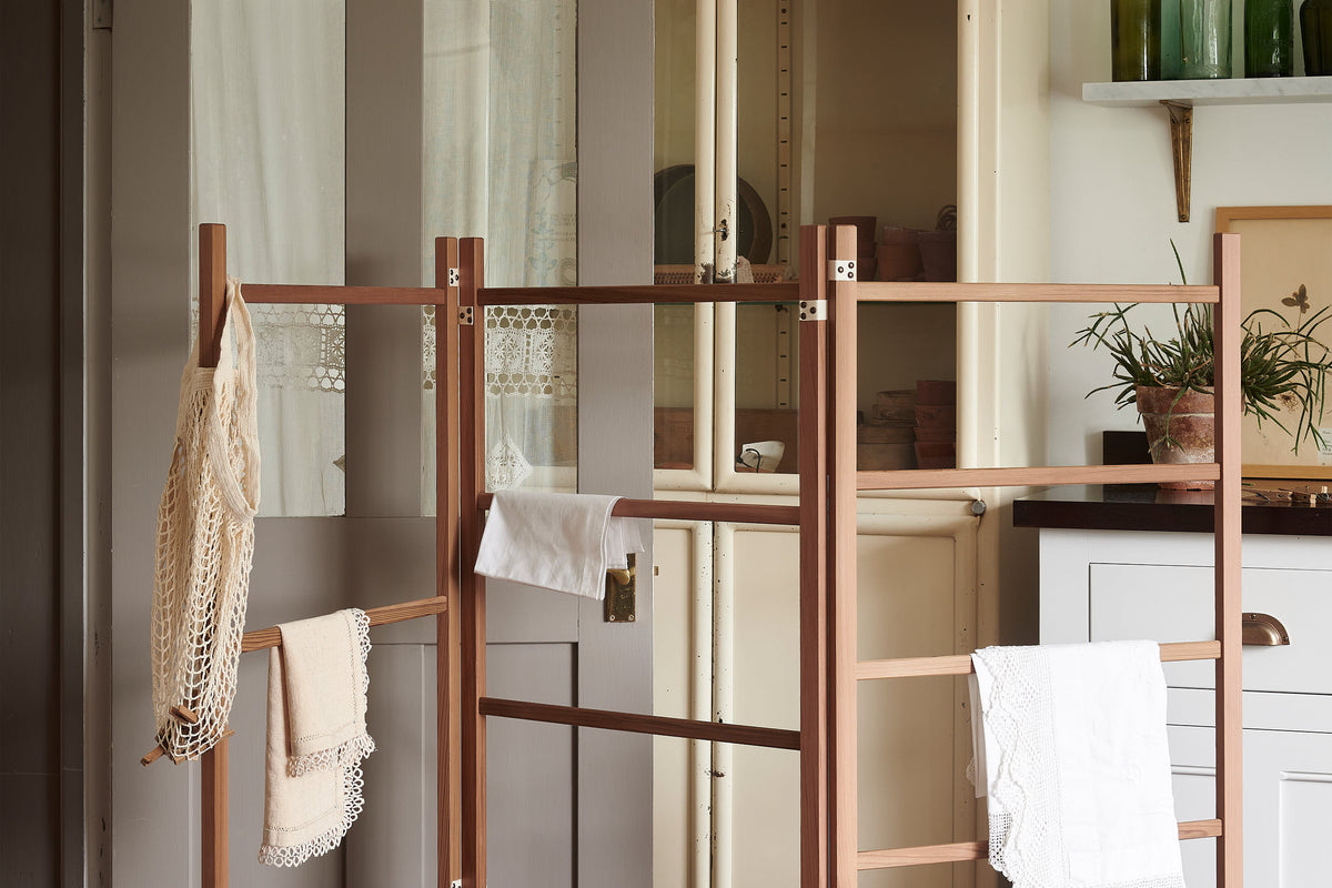 A close-up of the clothes horse with delicate whites and creams textiles.