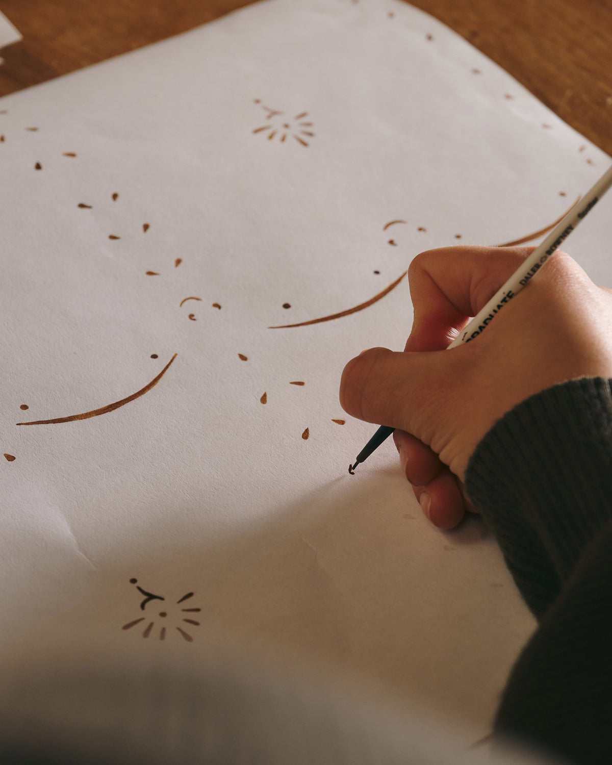 An artist is drawing the pattern for the wallpaper.