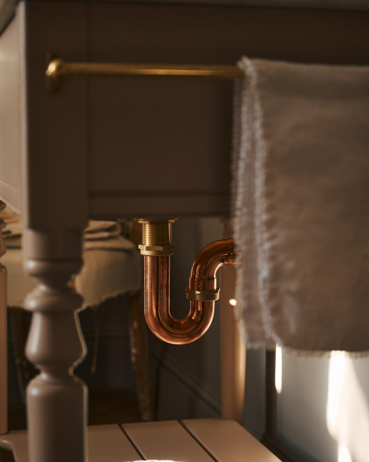 A copper p-trap fitted to a Victorian-inspired washstand. TEST