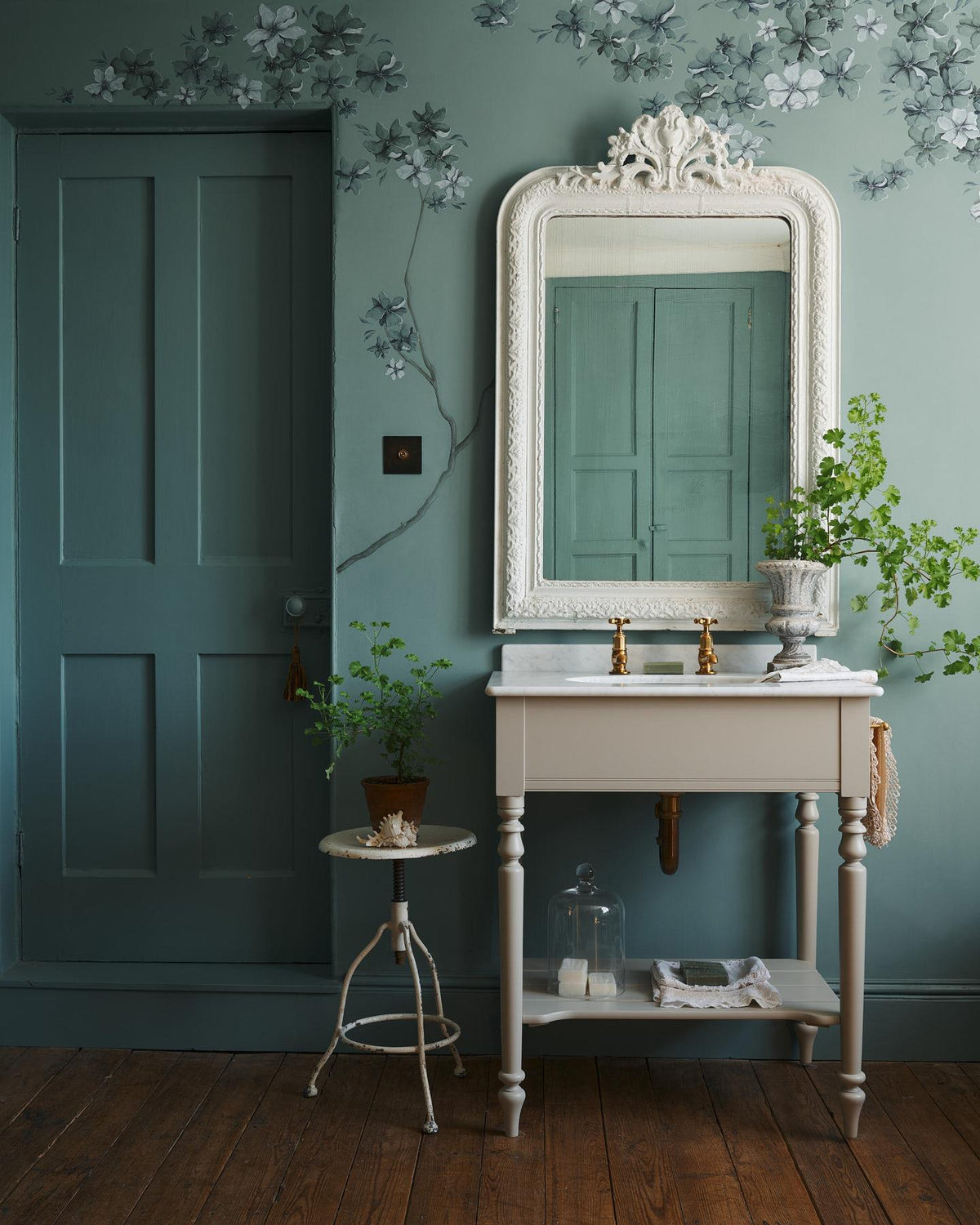A straight-on view of a mushroom-grey Victorian-inspired washstand with brass pillar taps in a duck-egg blue painted room. The room is classic and bohemian with an ornate white mirror and elegant painted flowers across the top of the walls. | Medium Mushroom shown TEST