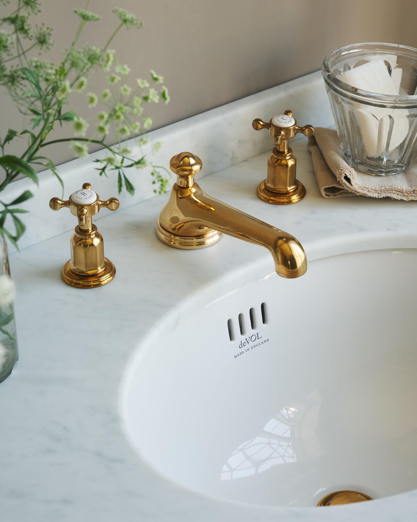 A close-up oblique view of an aged brass mixer tap for a bathroom basin sink.