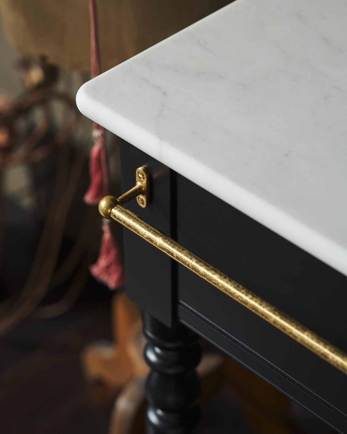 A detailed view of an aged brass towel rail attached on the front of a Victorian-inspired washstand. | Front Towel Rail shown TEST