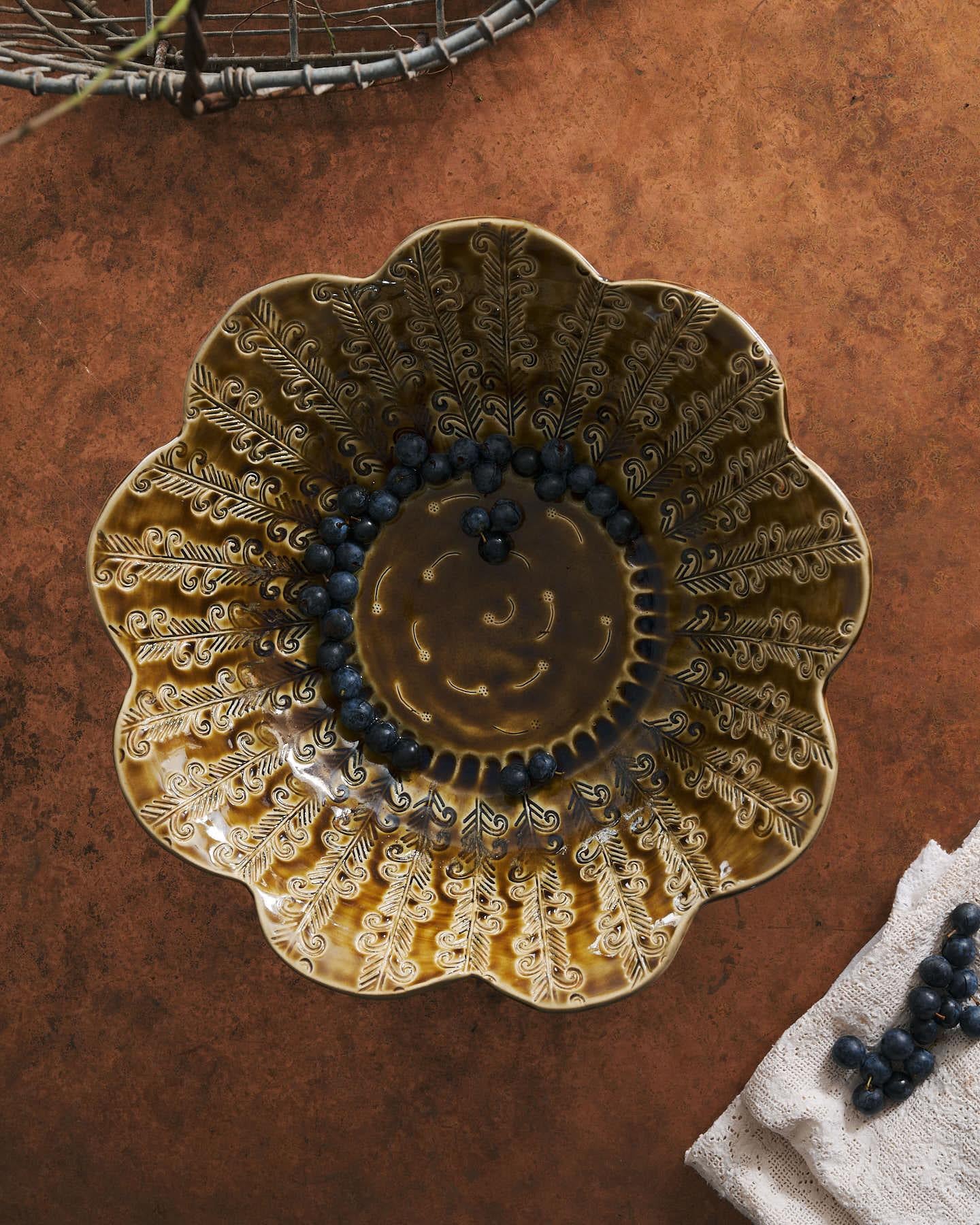 Heirloom Petal Bowl in Dark Gold Colour with blueberries on a copper worktop.