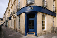 The deVOL George Street, Bath showroom is a traditional tall, three floor, bath stone building with the iconic deVOL blue on the rim of the pillars of the front door, signs and a golden deVOL logo.