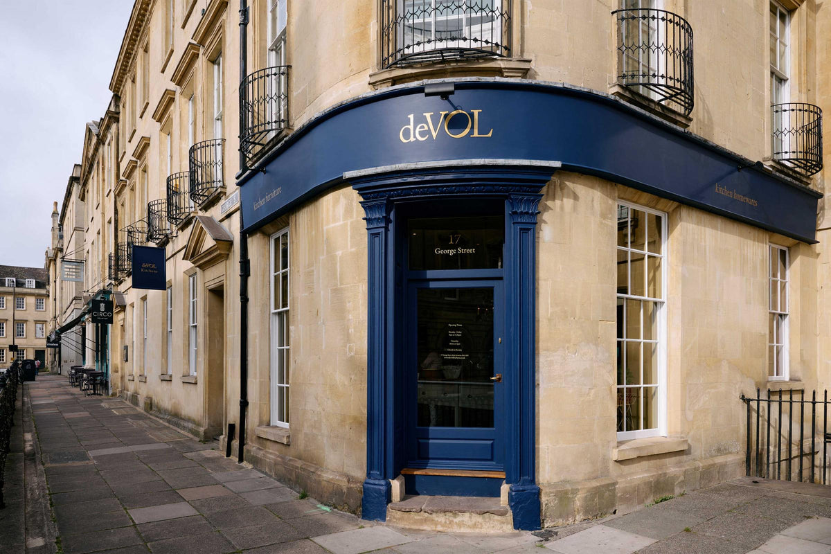 The deVOL George Street, Bath showroom is a traditional tall, three floor, bath stone building with the iconic deVOL blue on the rim of the pillars of the front door, signs and a golden deVOL logo.