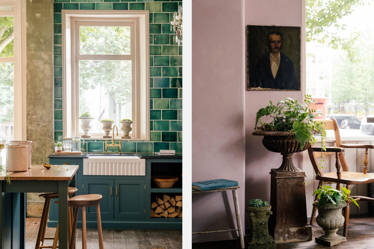 A playful pastel yet classic kitchen features a Clerkenwell blue sink run with a black granite worktop, emerald green splashback tiles, a single fluted Belfast sink, and an aged brass Ionian tap. A long kitchen island with a breakfast nook and deVOL bum stools adds charm. Decorated with chopped firewood, vintage ceramics, and a crystal chandelier, this kitchen has both functionality and personality.