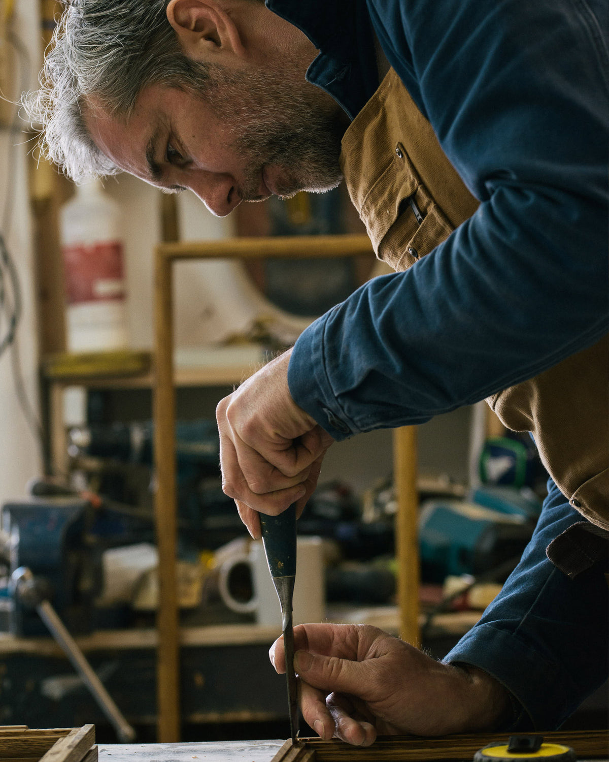 A wood crafter carefully adding framed panels on wood.