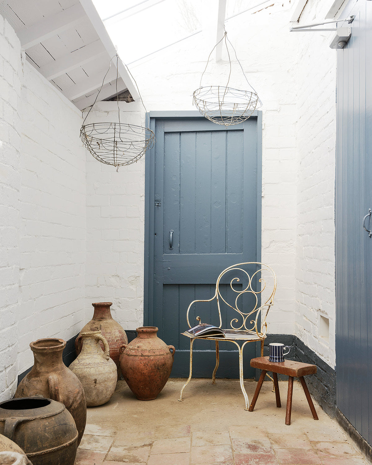 In a quiet corner of a Cotes Mill is a seating area with a few pieces of vintage furniture and large reclaimed ceramic pots.