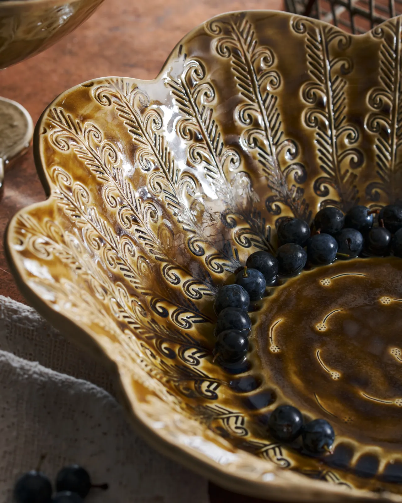 Heirloom Petal Bowl in Dark Gold Colour with blueberries on a copper worktop.