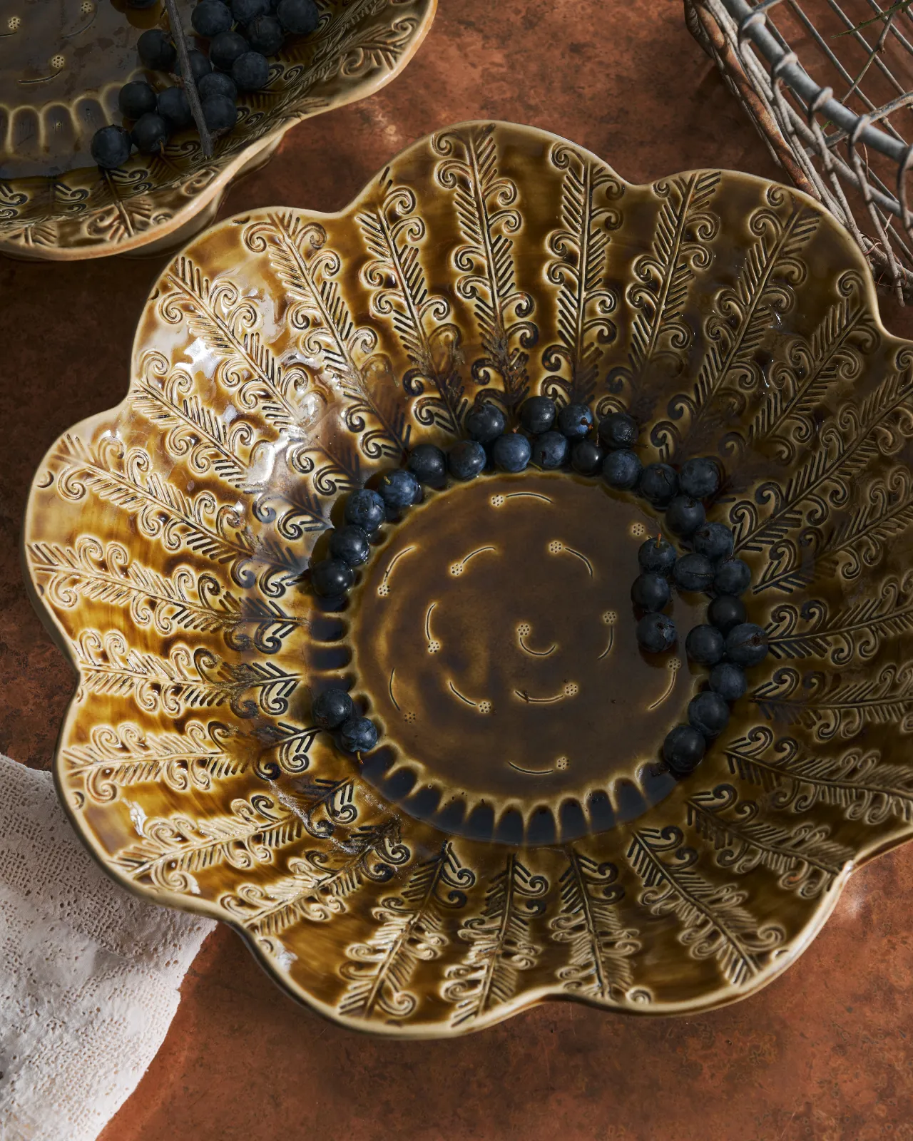 Heirloom Petal Bowl in Dark Gold Colour with blueberries on a copper worktop.