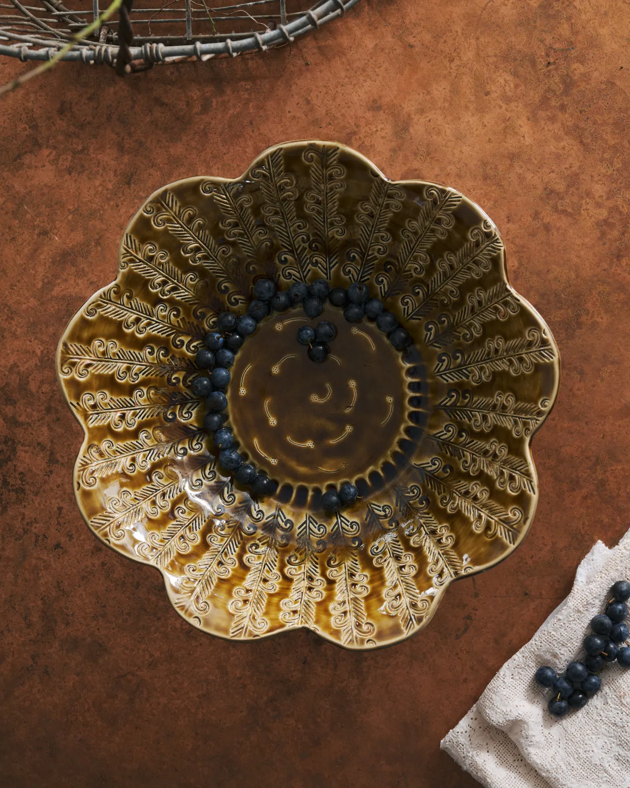 Heirloom Petal Bowl in Dark Gold Colour with blueberries on a copper worktop.