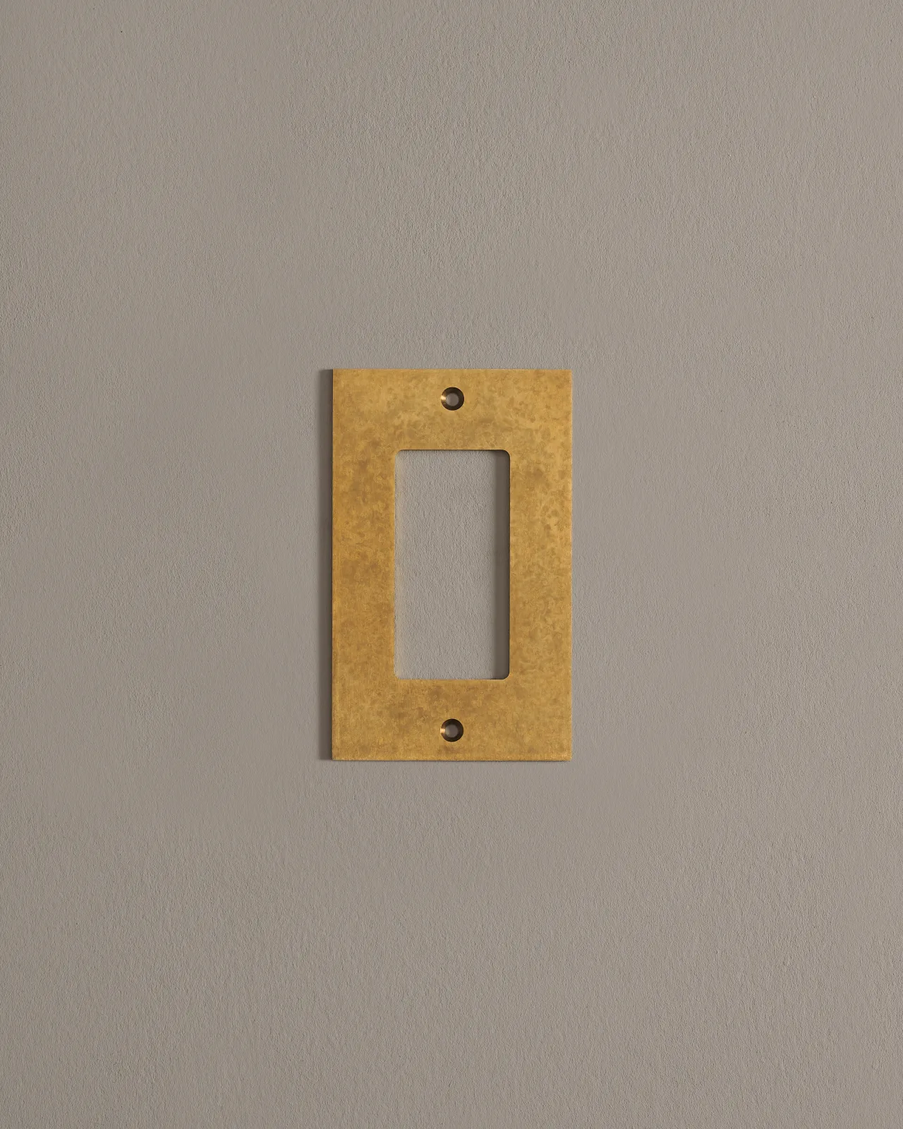 A front on shot of a cover plate in aged brass finish.