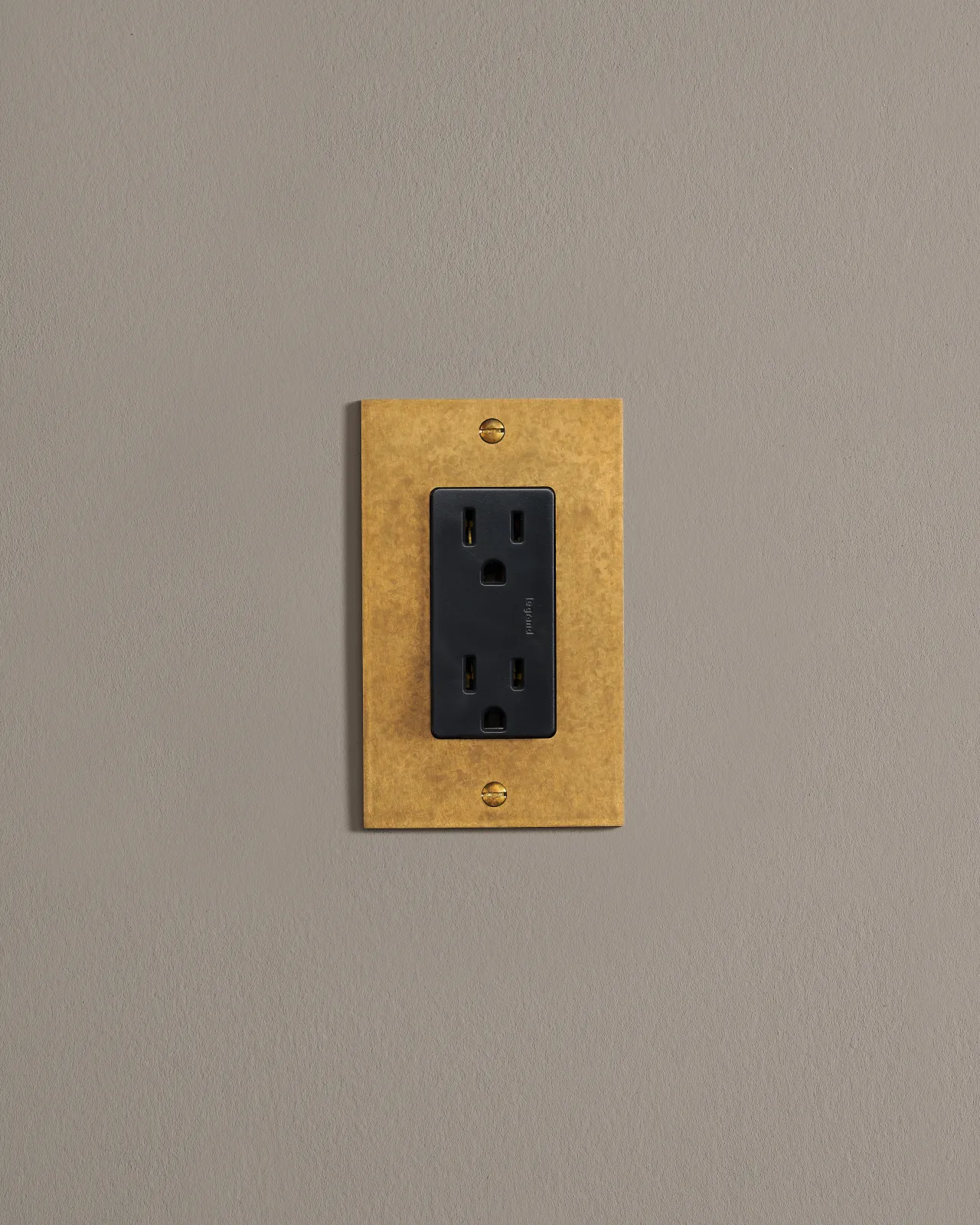 a front on shot of the standard outlet on an aged brass plate.