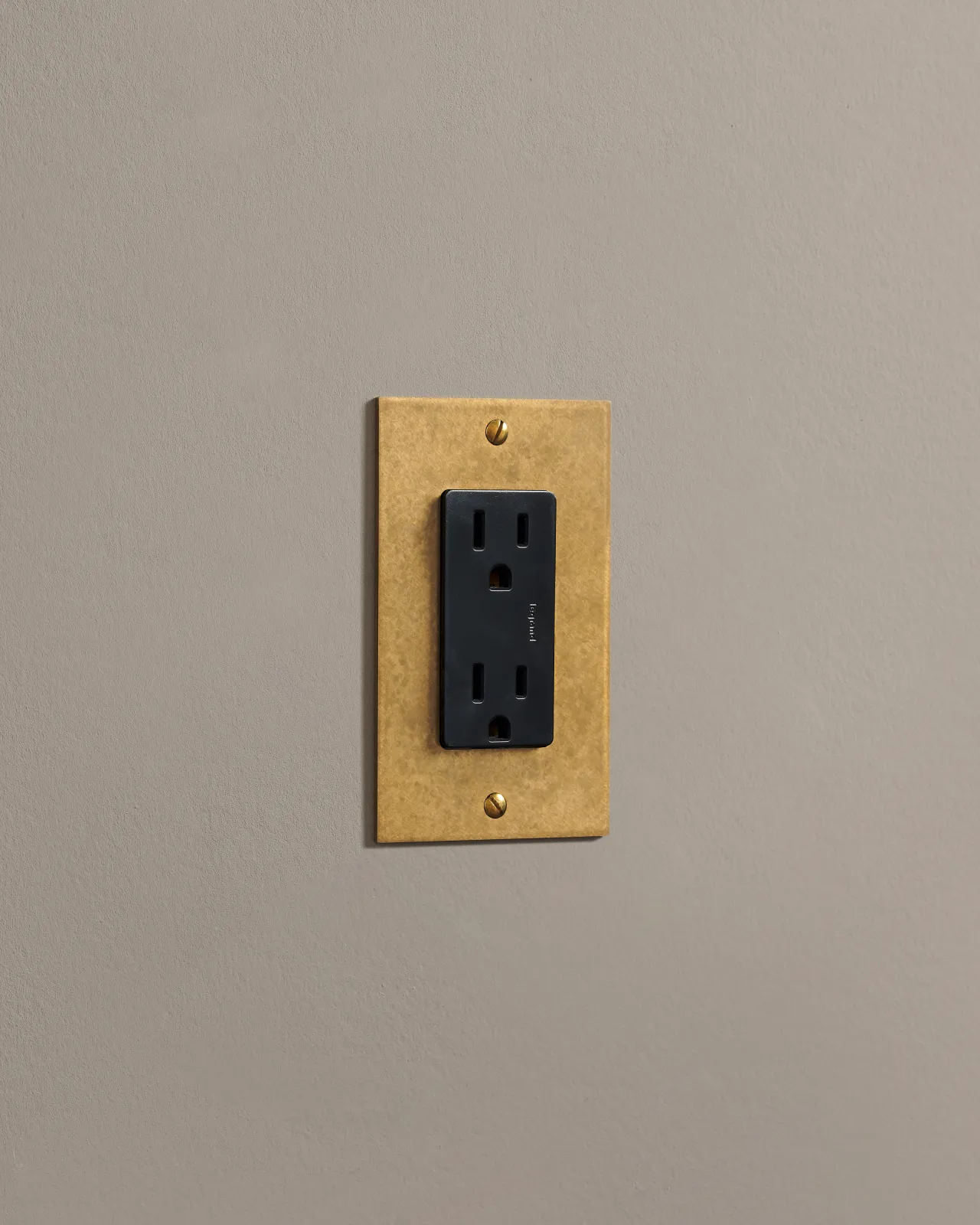 a side on shot of the standard outlet on an aged brass plate.