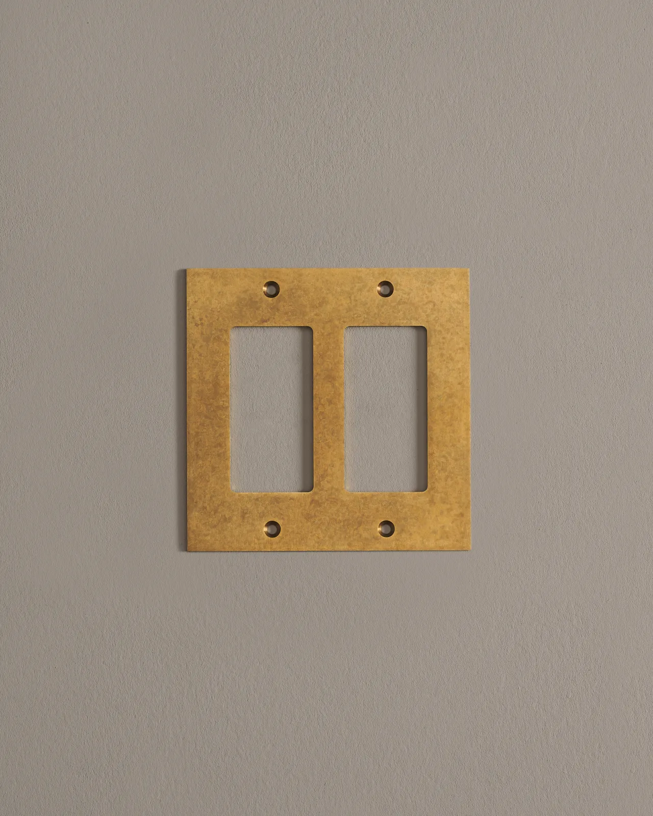 A front on shot of a cover plate in aged brass finish.