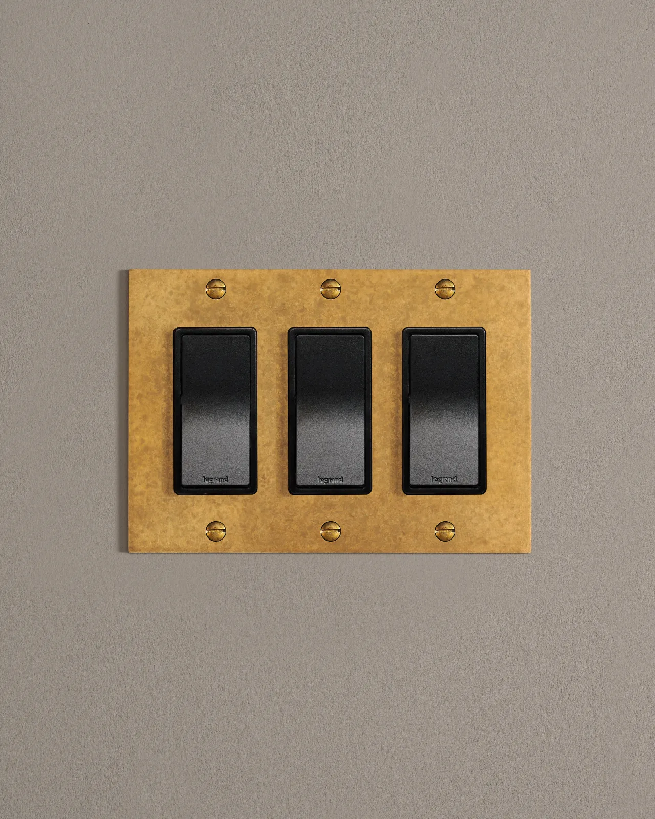 a front on shot of the rocker switch on an aged brass cover plate.