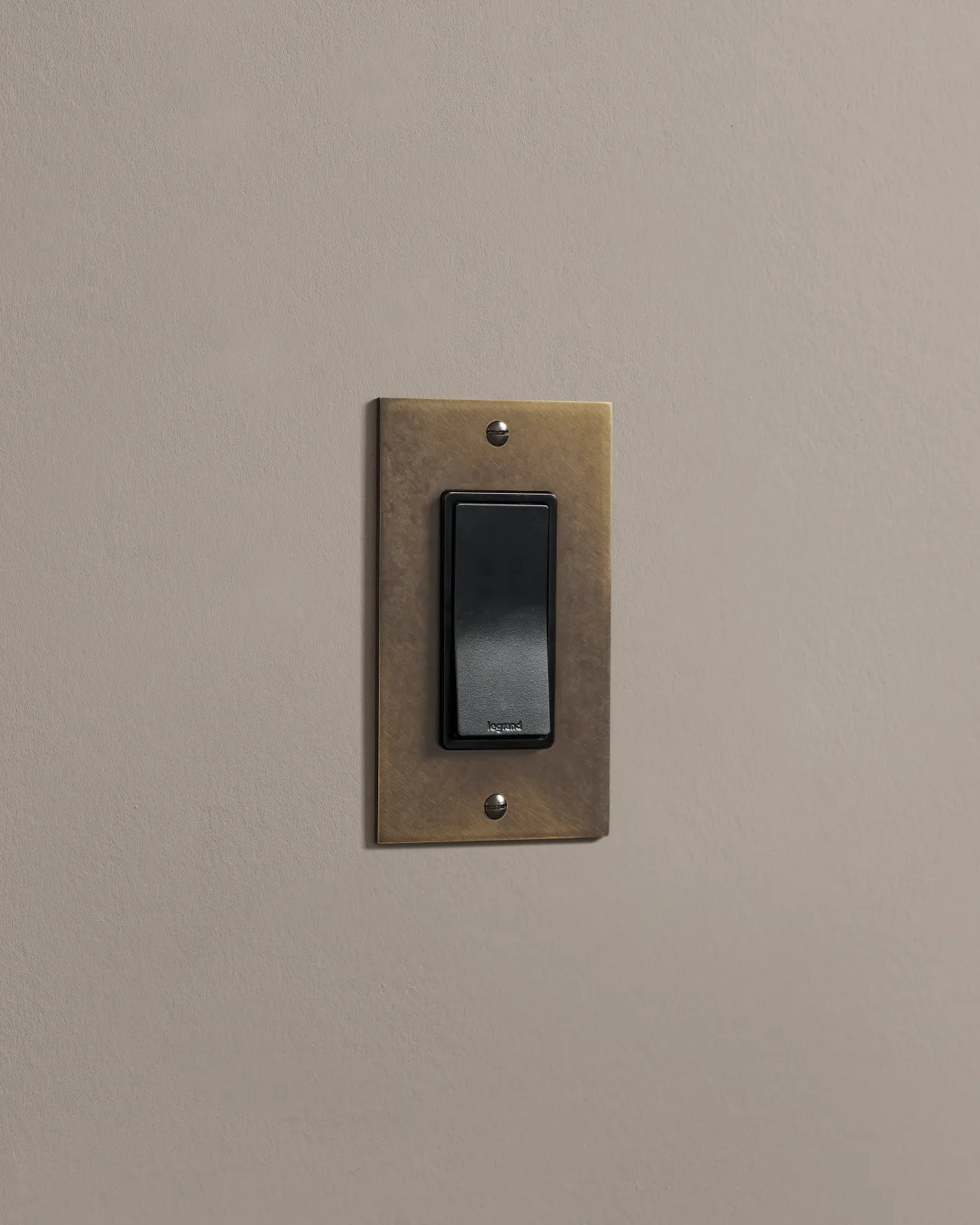 a side on shot of the rocker switch on an oxidised brass plate.