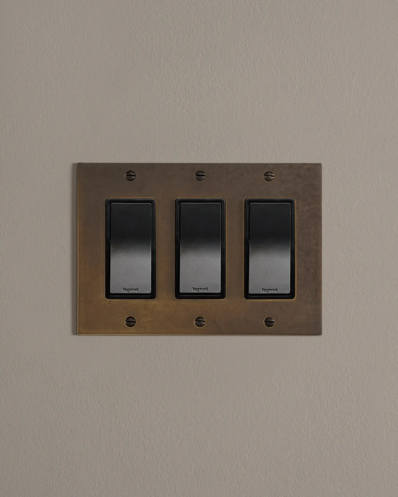 a front on shot of the rocker switch on an oxidised brass plate.
