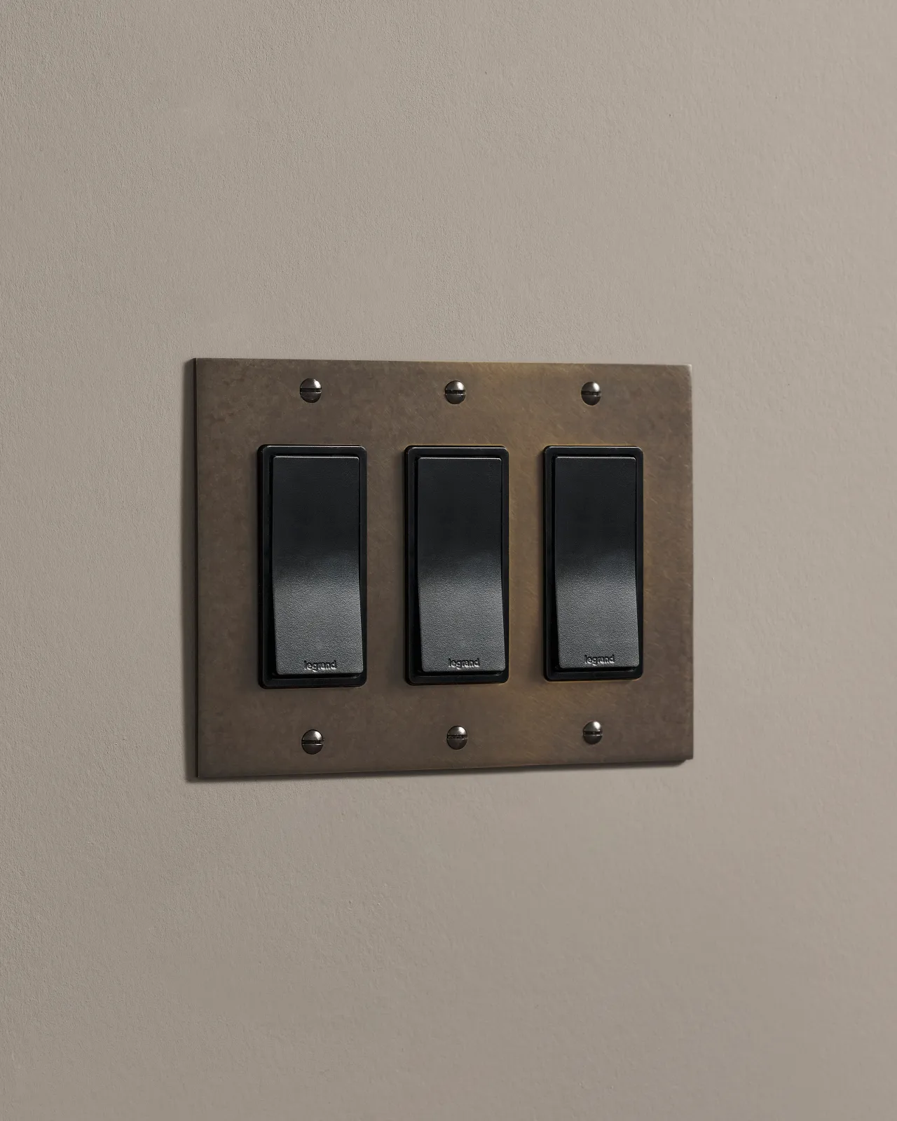 a side on shot of the rocker switch on an oxidised brass plate.