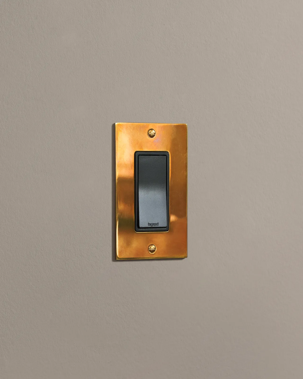 a side on shot of the rocker switch on an heirloom brass plate.