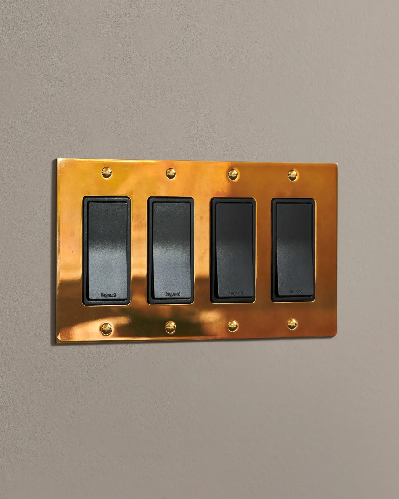 a side on shot of rocker switch the on an heirloom brass plate.
