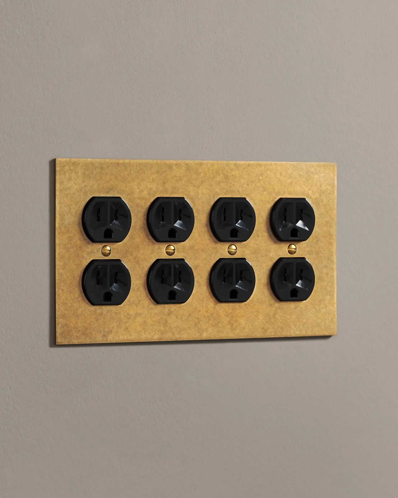 A side on shot on a duplex outlet on an aged brass cover plate.