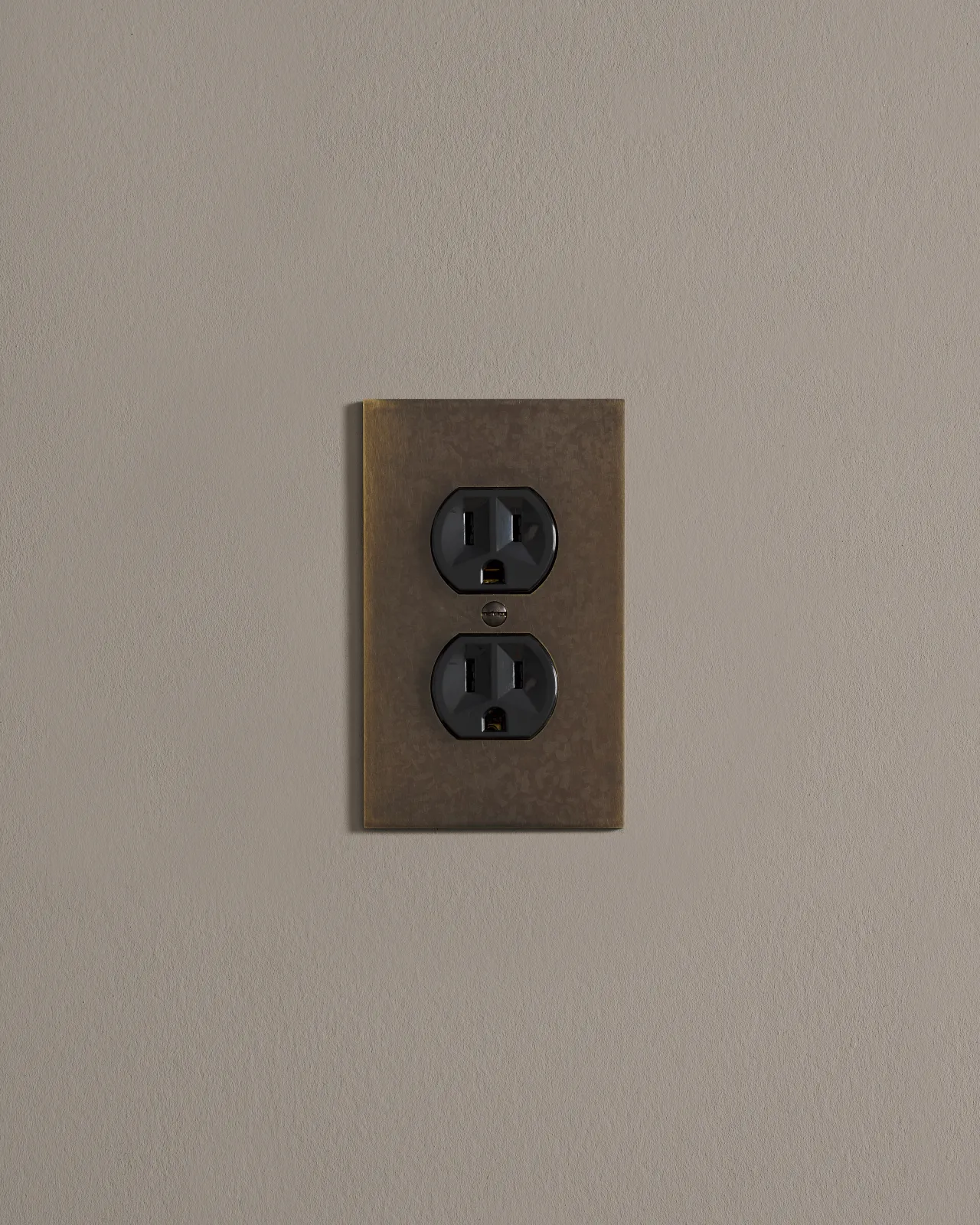 a front on shot of the duplex outlet on oxidised brass cover plate.