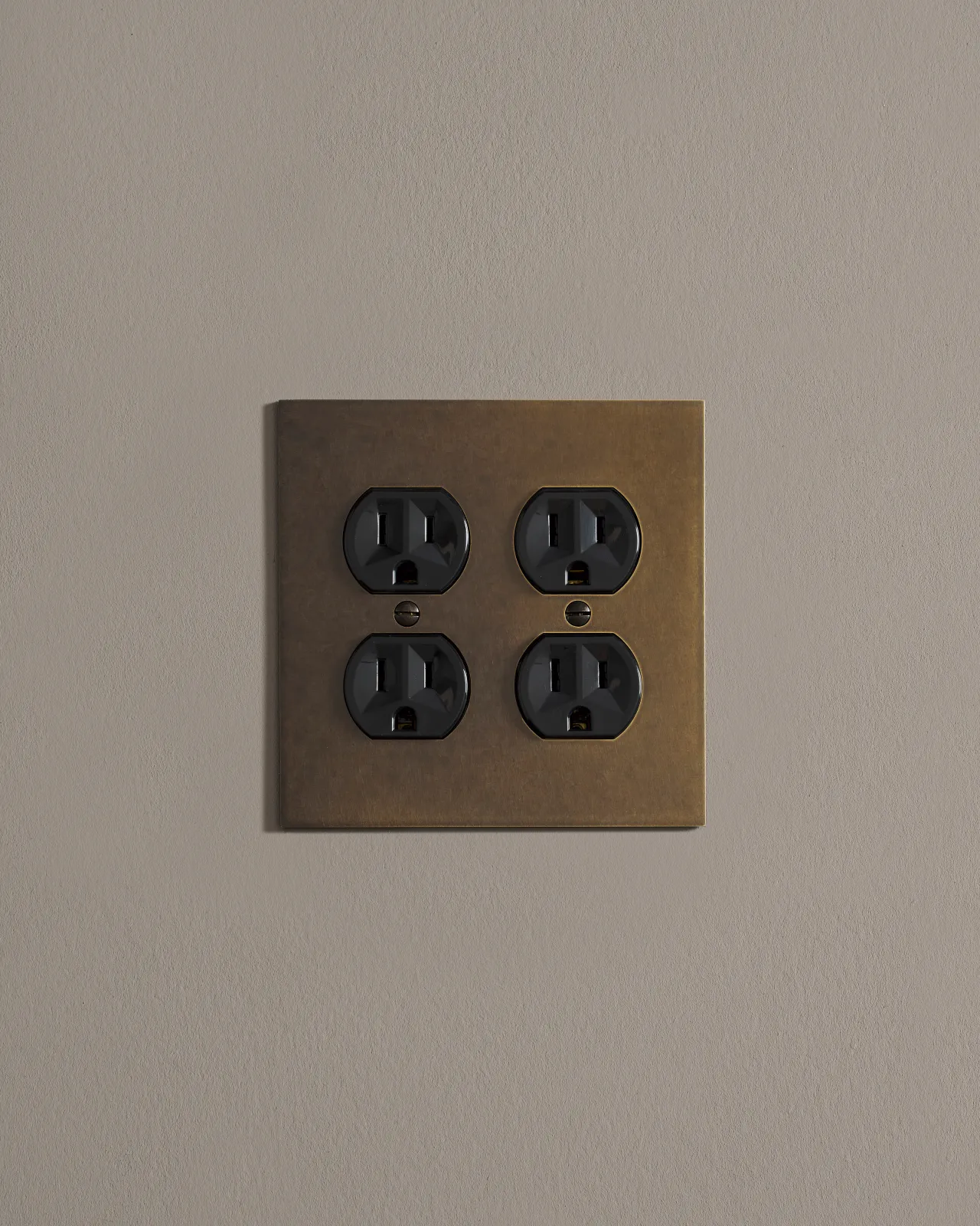 a front on shot of the duplex outlet on oxidised brass cover plate.