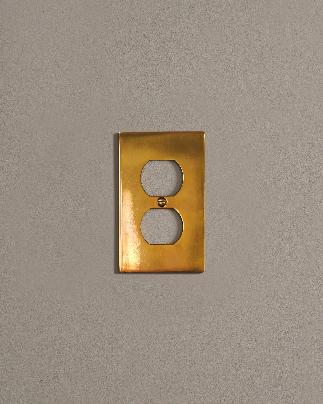 a front on shot of the duplex outlet cover plate in heirloom brass.