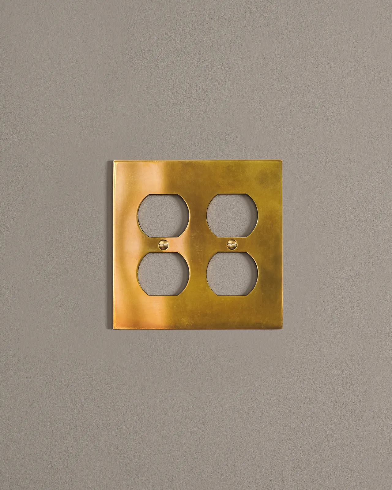 a front on shot of the duplex outlet cover plate in heirloom brass.