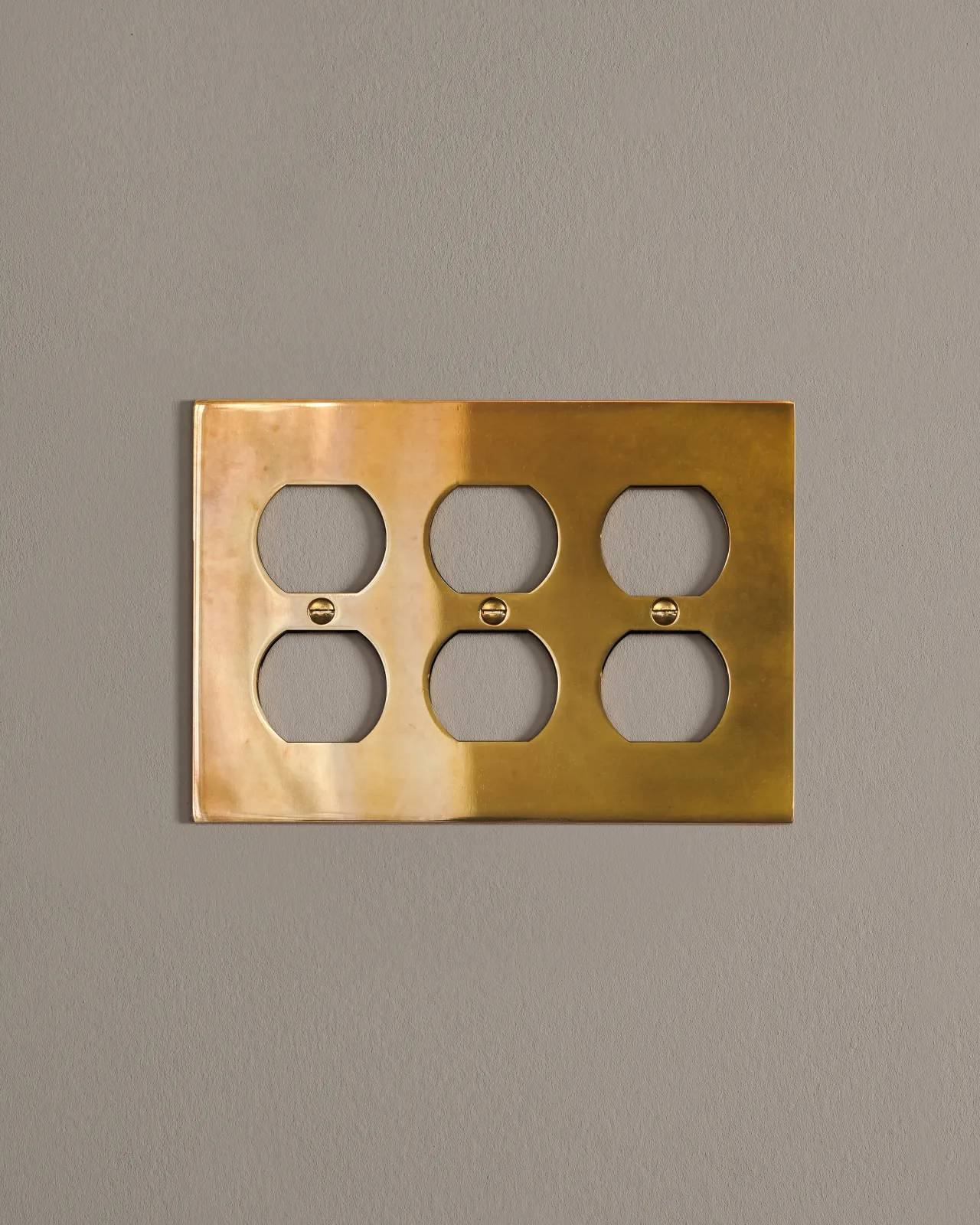 a front on shot of the duplex outlet cover plate in heirloom brass.