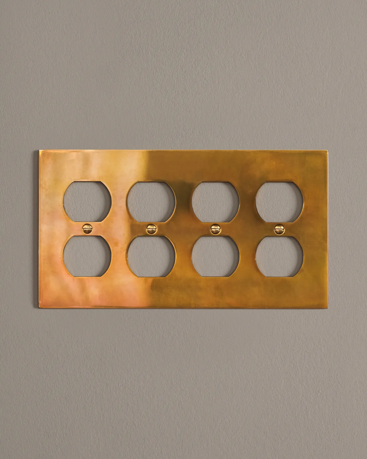 a front on shot of the duplex outlet cover plate in heirloom brass.