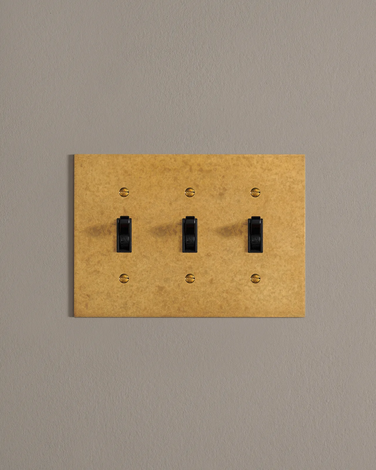 A front on shot on a toggle switch on an aged brass cover plate.