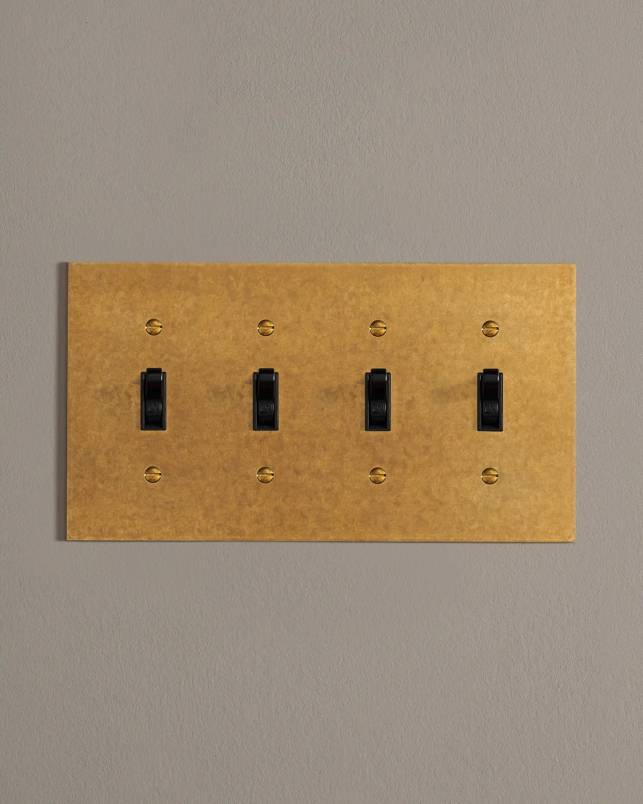 A front on shot on a toggle switch on an aged brass cover plate.