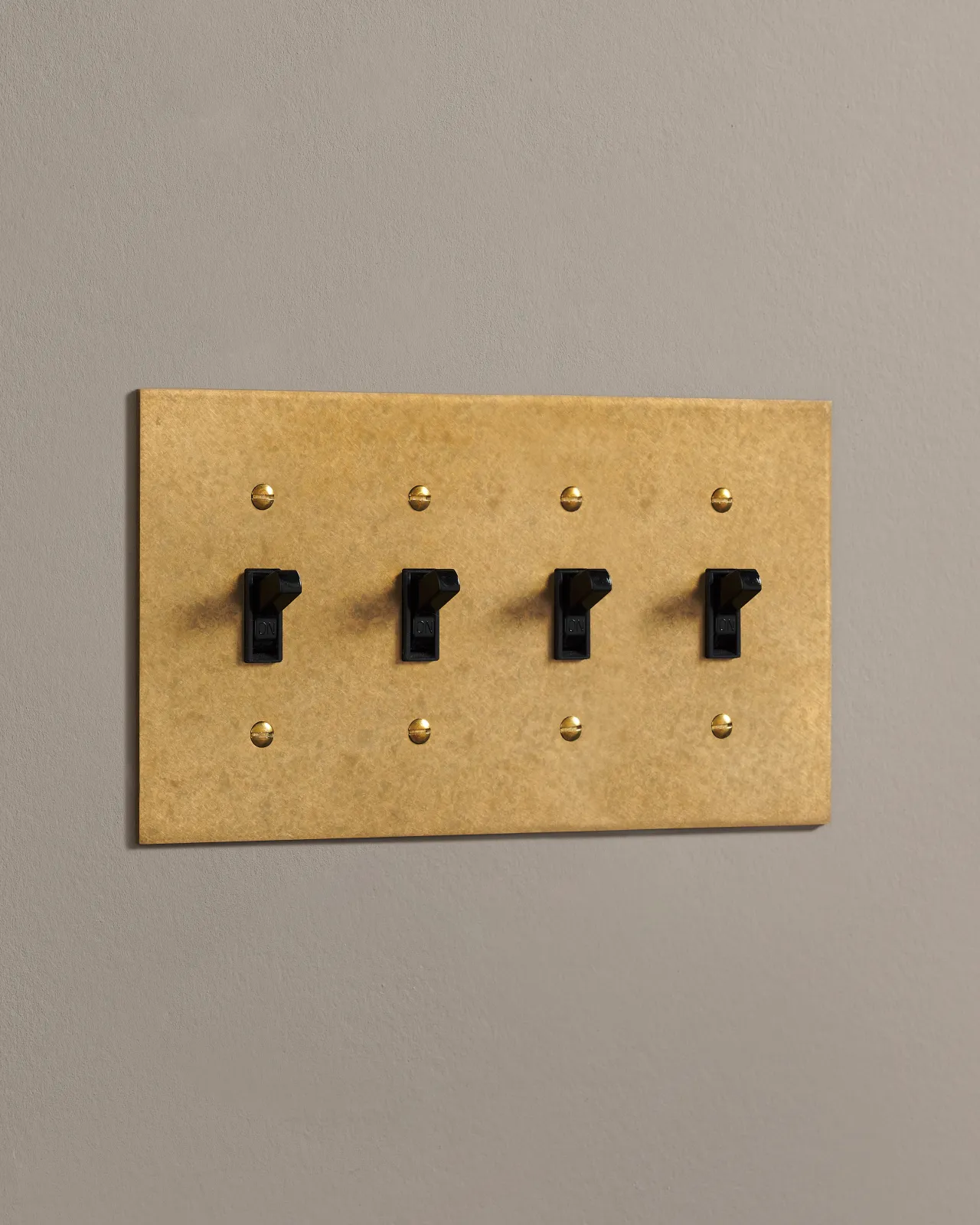 A side on shot on a toggle switch on an aged brass cover plate.