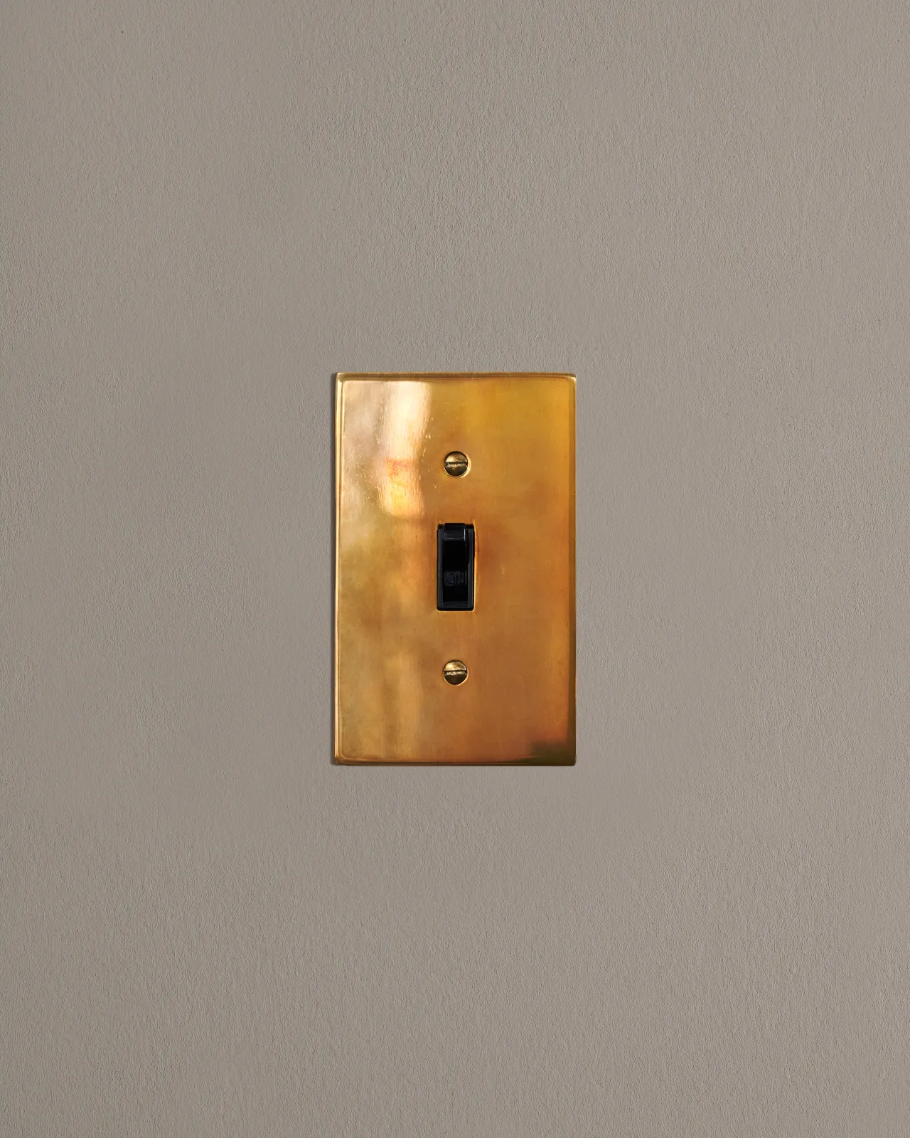 a front on shot of the toggle switch on an heirloom brass cover plate.