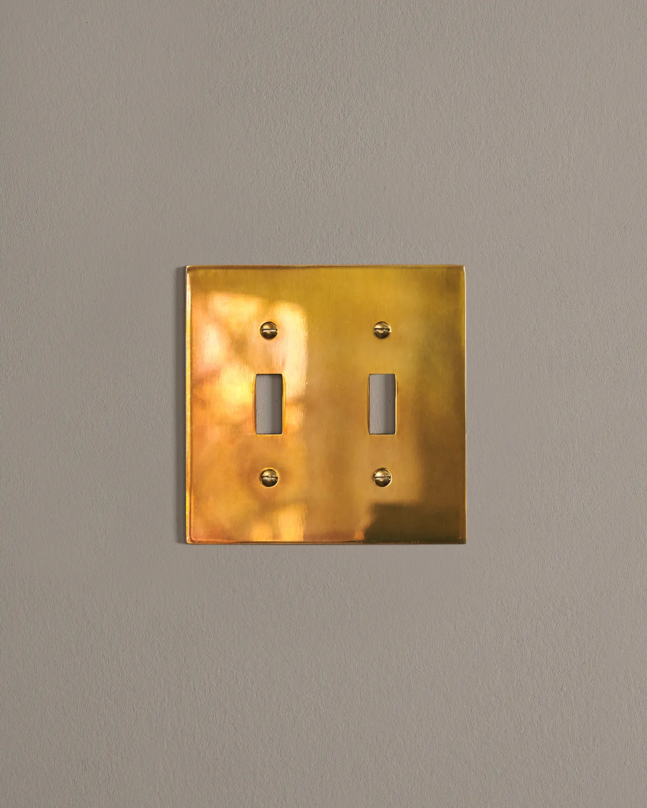 a front on shot of the toggle switch cover plate in heirloom brass.