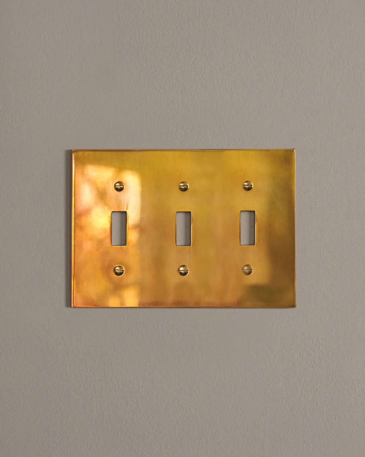 a front on shot of the toggle switch cover plate in heirloom brass.