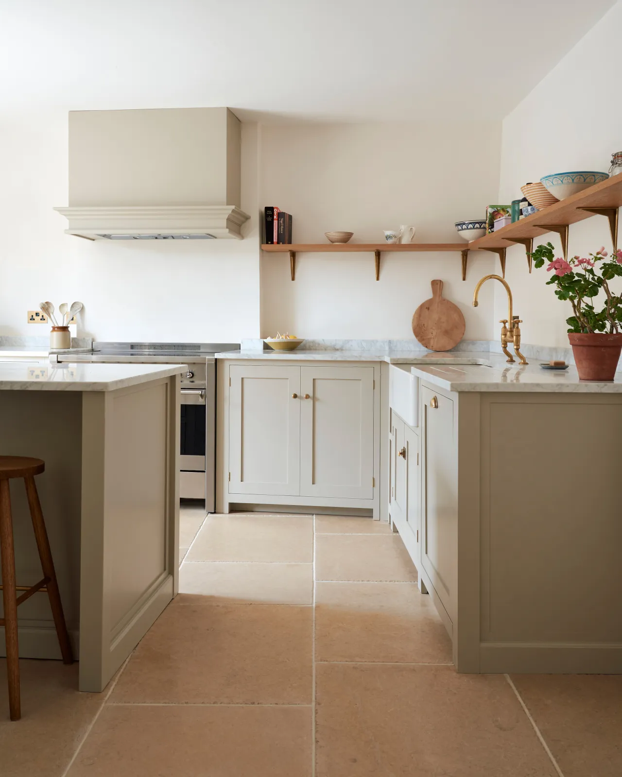 Vintage Bronze Limestone flooring in a simple Shaker-style kitchen with Mushroom painted cupboards and white walls.