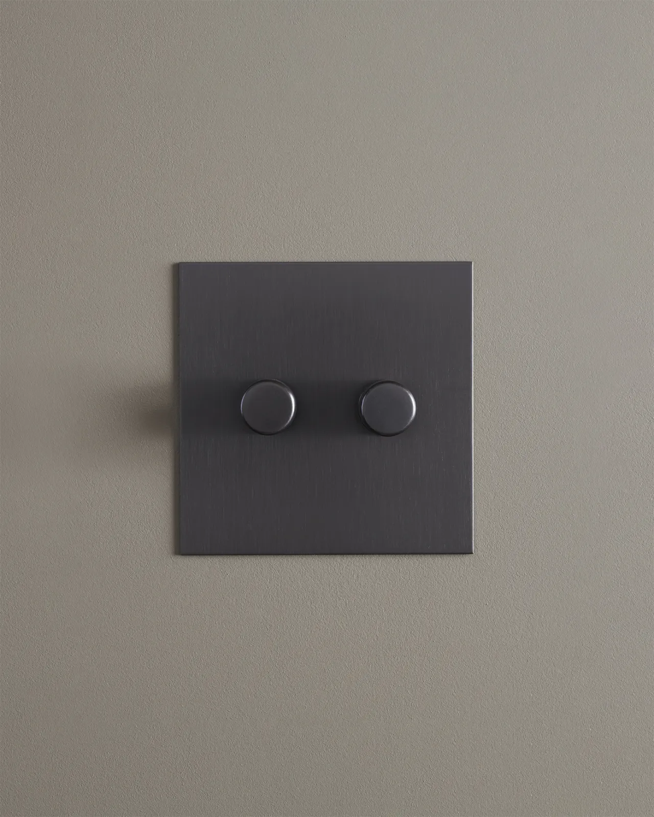 A straight-on view of a 2 gang dimmer switch in an antiqued bronze finish.