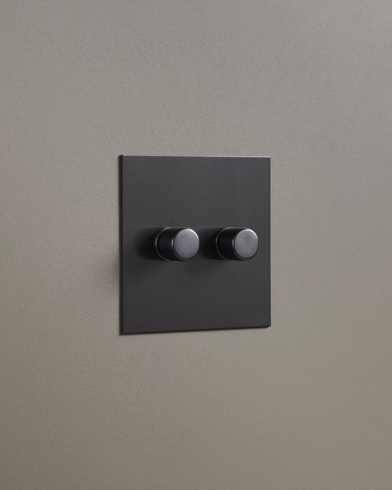 An oblique view of a 2 gang dimmer switch in an antiqued bronze finish.