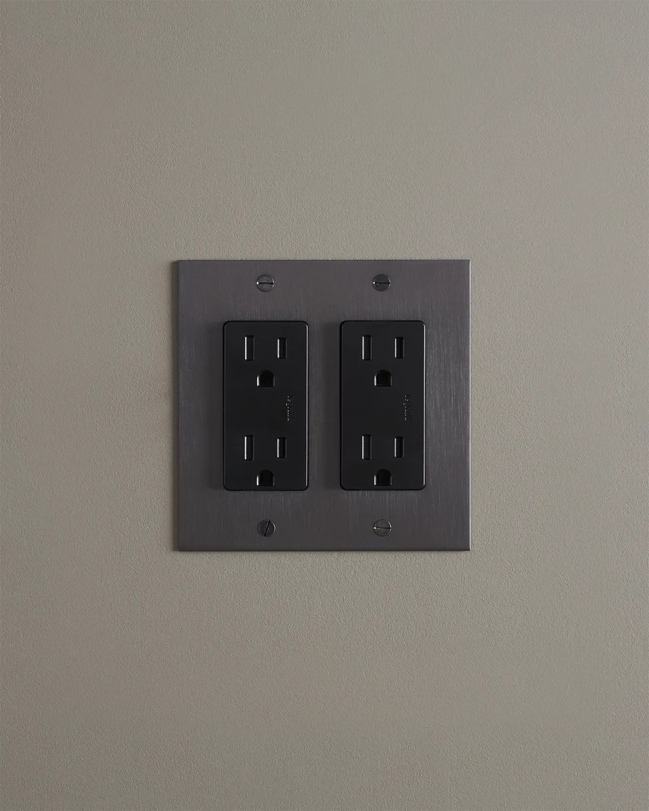 A straight-on view of a quad duplex outlet in an antiqued bronze finish.