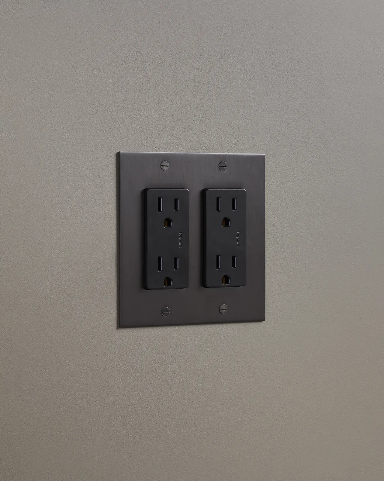 An oblique view of a quad duplex outlet in an antiqued bronze finish.