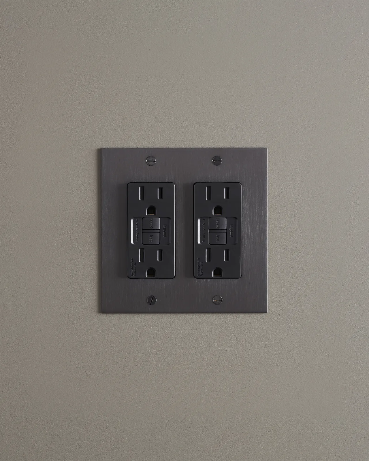 A straight-on view of a quad duplex GFCI outlet in an antiqued bronze finish.