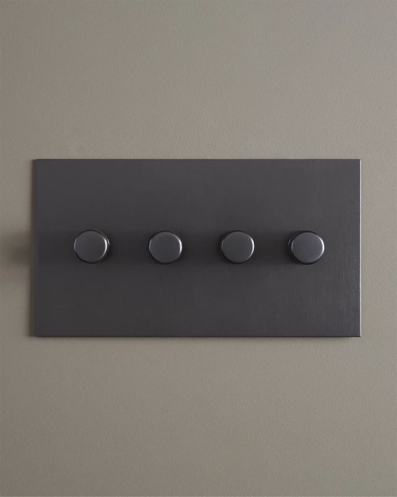 A straight-on view of a 4 gang dimmer switch in an antiqued bronze finish.