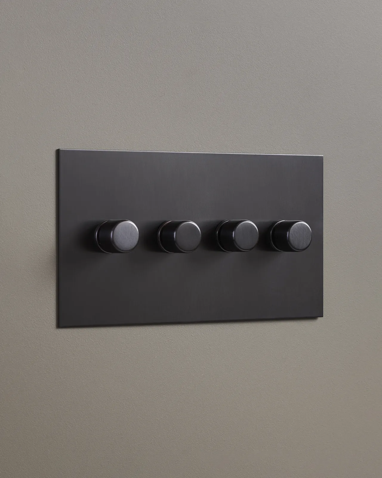 An oblique view of a 4 gang dimmer switch in an antiqued bronze finish.