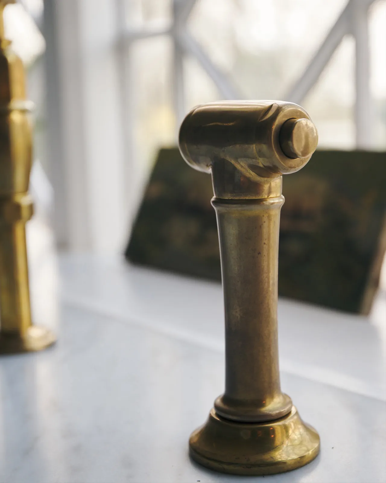 A close-up view of a traditional-style aged brass rinser tap.